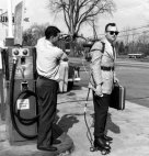 გაყიდვების აგენტი ავსებს თავისი ელექტროროლიკების ბაკს ბენზინგასამართ სადგურზე, 1961 წელი